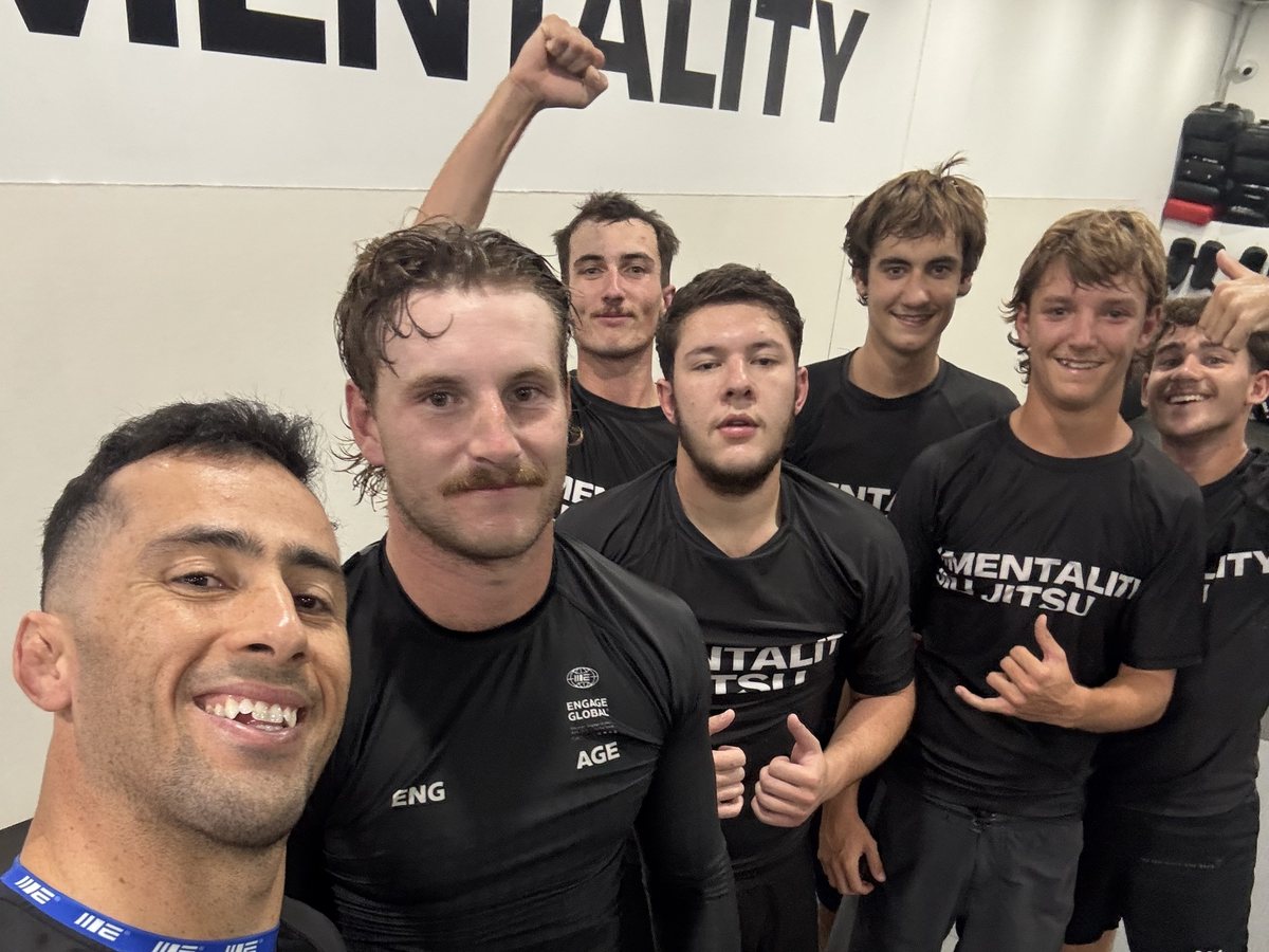 Members in rash guards smiling in a selfie after a No-Gi session
