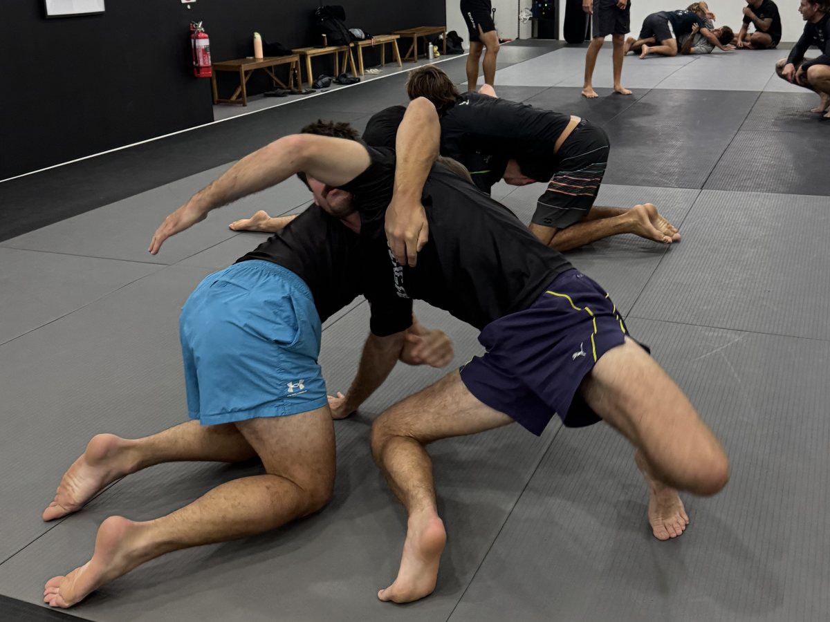 Members drilling a No-Gi scramble on the mats