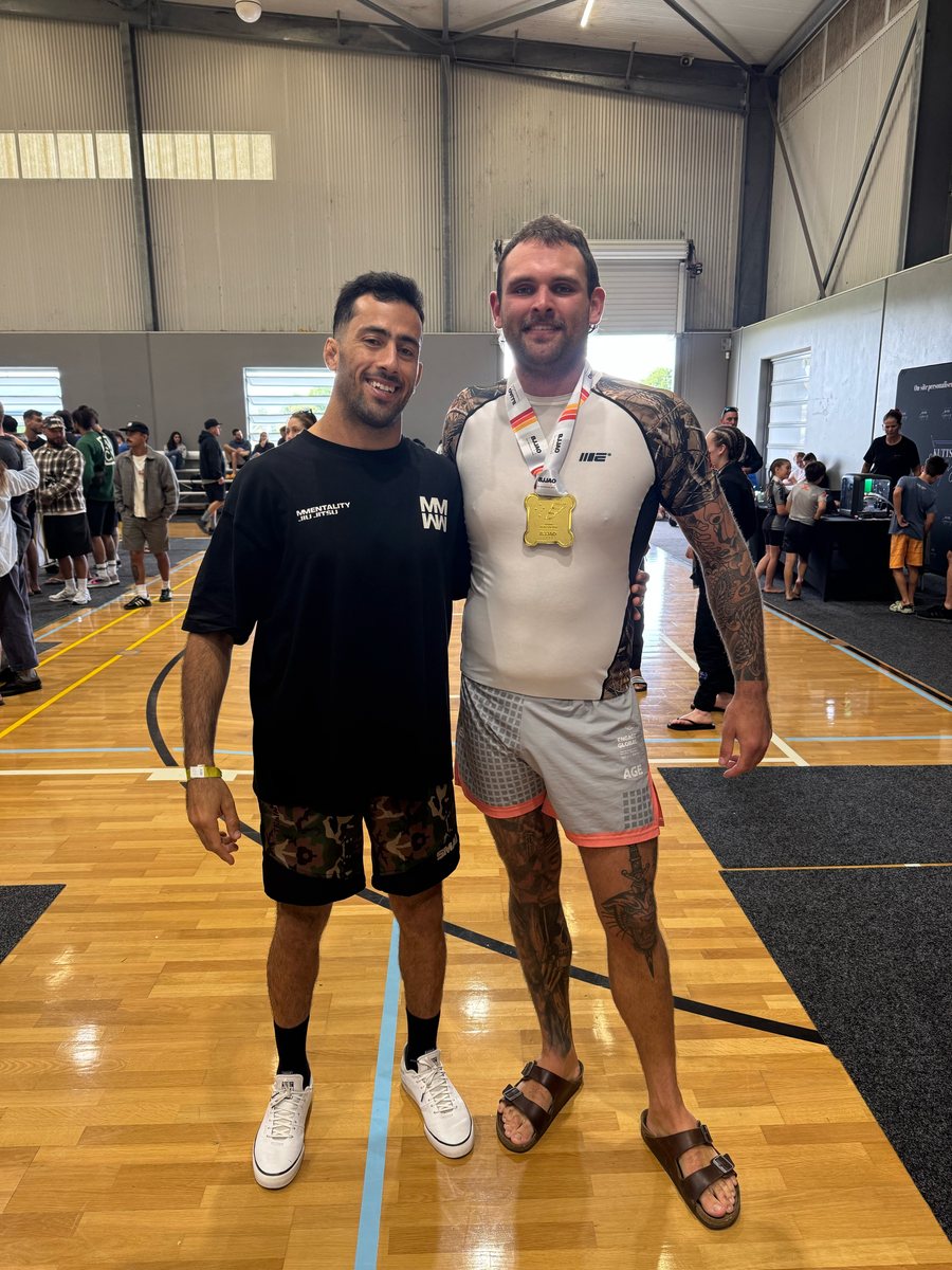 Coach William Moraes with a Mentality Jiu Jitsu member wearing a gold medal at a tournament