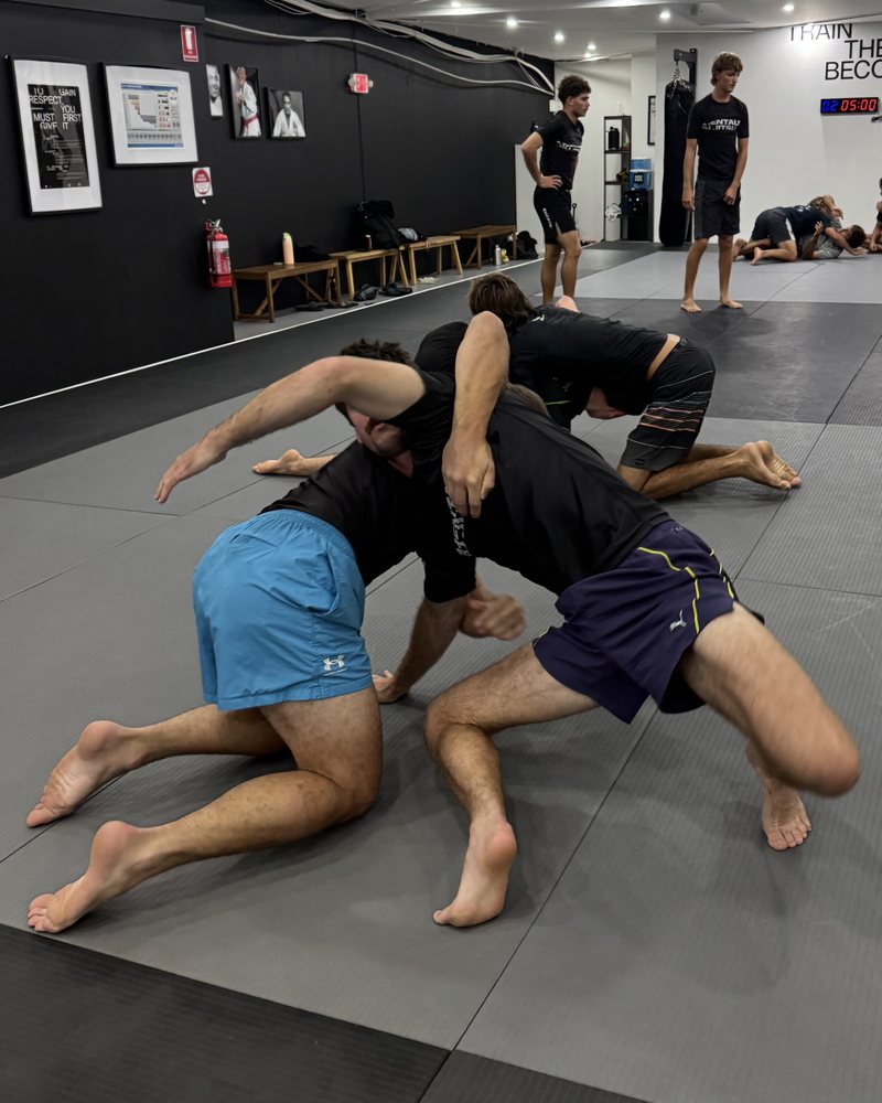 Members drilling a No-Gi scramble on the mats